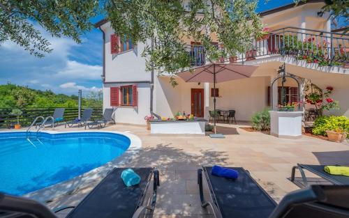a villa with a swimming pool and a house at Serene Summer Oasis - Pool, Jacuzzi, Sauna, Sea View - Lara in Drenje
