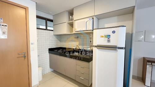a kitchen with a white refrigerator and a sink at Eco Summer Tambaú WB Genius Flats in João Pessoa