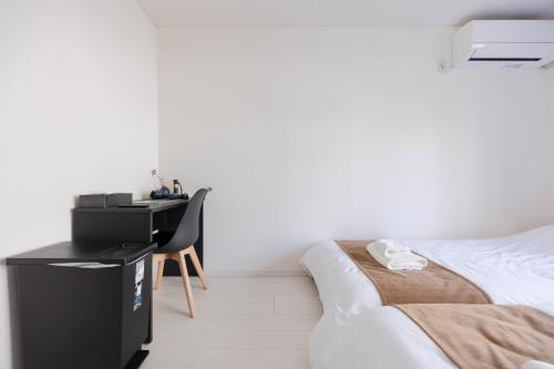 a bedroom with a bed and a desk in it at Kawagoe Good Place House in Kawagoe