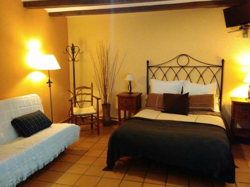 a hotel room with a bed and a chair at Can Marc in Sant Esteve de Palautordera