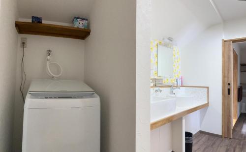 a bathroom with a sink and a washing machine at とっくりhouse in Takashima
