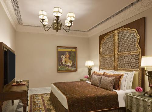 a bedroom with a large bed and a television at Jai Mahal Palace in Jaipur