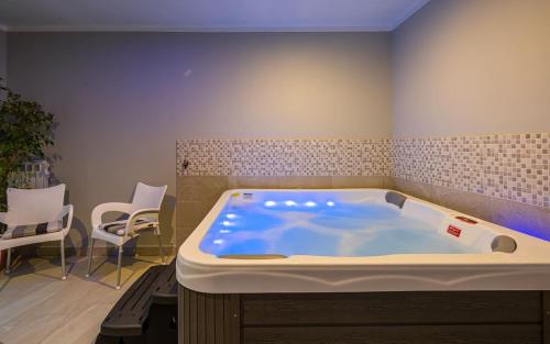a large bath tub in a room with chairs at Serene Summer Oasis - Pool, Jacuzzi, Sauna, Sea View - Lara in Drenje