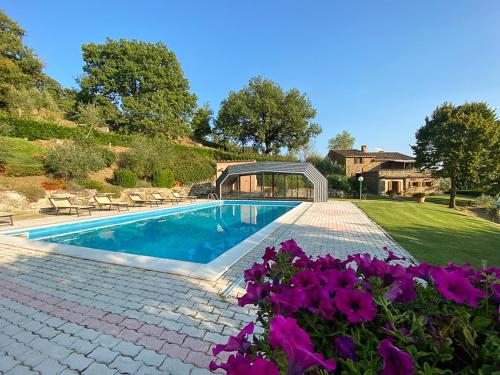 a swimming pool in a yard with purple flowers at Villa Beatrice - Private Heated Pool & Amazing Umbrian Landscape in Corgna