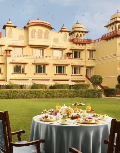 a table with food in front of a large building at Jai Mahal Palace in Jaipur