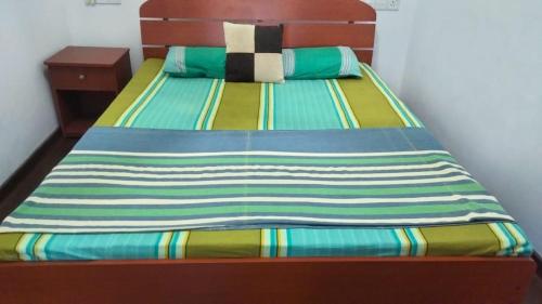 a bed with a colorful blanket on top of it at Princely House Apartment in Galle