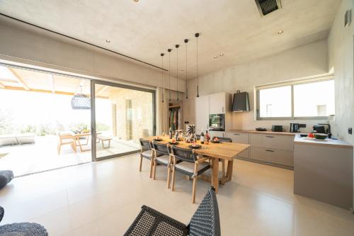 a kitchen with a wooden table and chairs at Lithos Art Villas in Sarlata