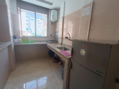 a small kitchen with a refrigerator and a sink at Future in Taghazout