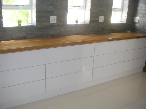 a kitchen counter with white cabinets and two windows at Waterside Living MM1297 in Jeffreys Bay