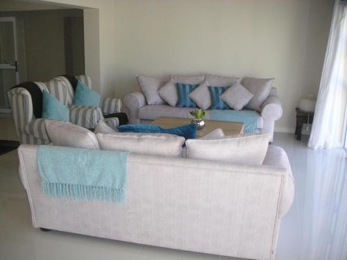 a living room with two couches and a table at Waterside Living MM1297 in Jeffreys Bay