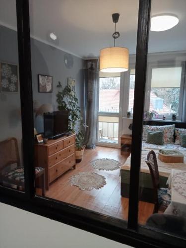 a reflection of a living room with a mirror at Apartament Dobre Miejsce in Malbork