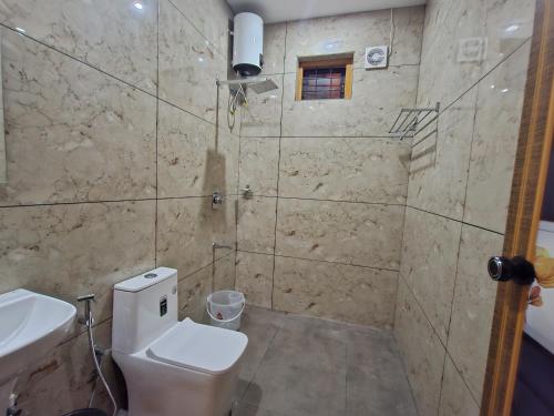 un baño con inodoro y lavabo en Zira Homestay, en Munnar