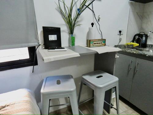 a small kitchen with two stools and a laptop on a counter at Espectacular Departamento en Vicente Lopez ,Avenida San Martín 2248 in Vicente López