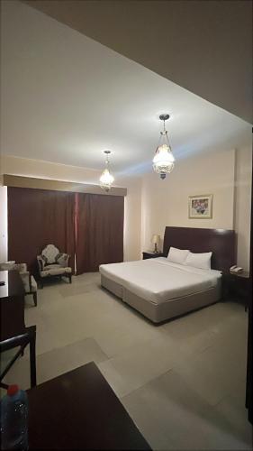 a bedroom with a large bed and two lights at Clifton International Hotel in Fujairah