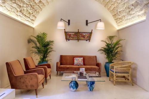 a living room with a couch and chairs and a table at Relais Antica Badia - San Maurizio 1619 in Ragusa