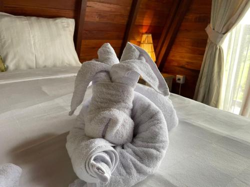 a towel animal sitting on top of a bed at Medukuh Point Hill in Karangasem