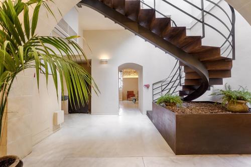 a hallway with a spiral staircase in a house at Relais Antica Badia - San Maurizio 1619 in Ragusa