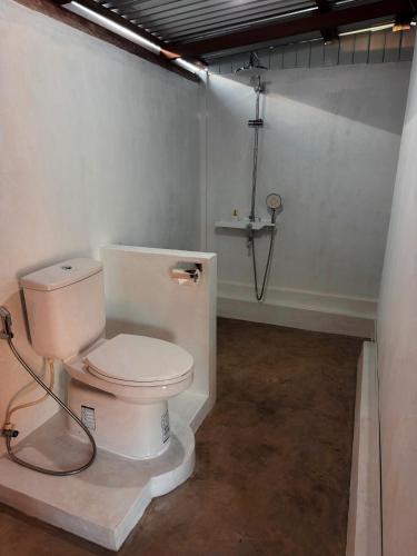 a bathroom with a white toilet in a room at The Breeze Glamping in Bangli