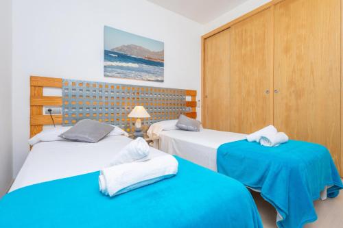 two beds in a room with blue and white at Villa Montfarrutx in Colonia de Sant Pere