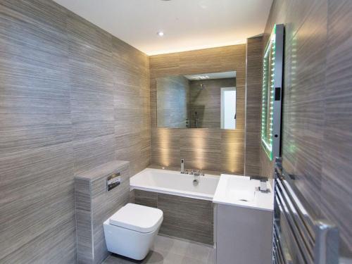 a bathroom with a toilet and a sink and a tub at 7 Atlantic Watch in St Ives