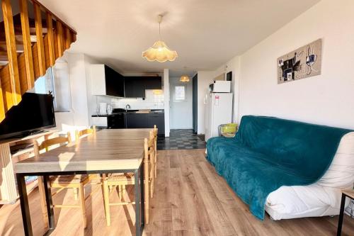 un salon avec un canapé vert et une table dans l'établissement Duplex - Balcon - Vue océan 180, à Guidel