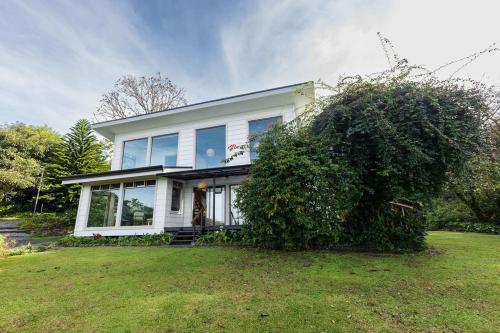 une maison avec un grand bush devant elle dans l'établissement Refugio Monteverde house, privacy & ocean view!, à Monteverde Costa Rica