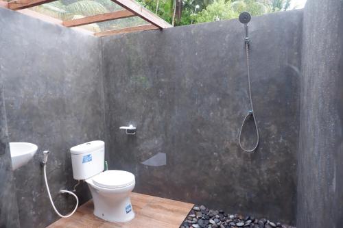 a bathroom with a shower with a toilet and a sink at Medukuh Point Hill in Karangasem