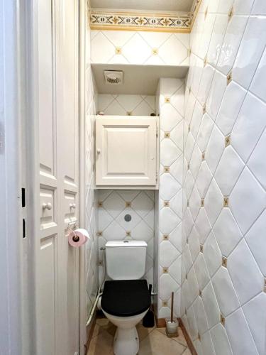 a small bathroom with a toilet with a black seat at Private room in shared apartment in Toulouse