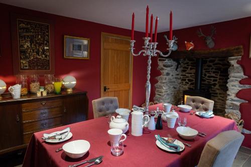ein Esszimmer mit einem Tisch und einem roten Tischtuch in der Unterkunft West Lyn Farm Bed & Breakfast in Lynton
