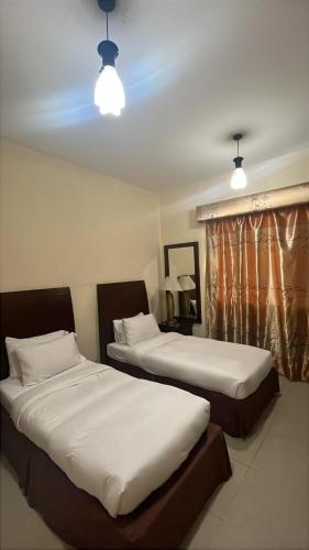 two beds sitting next to each other in a room at Clifton International Hotel in Fujairah