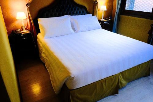a bedroom with a large bed with white sheets and pillows at H O T E L S A N G A L L O l in Venice