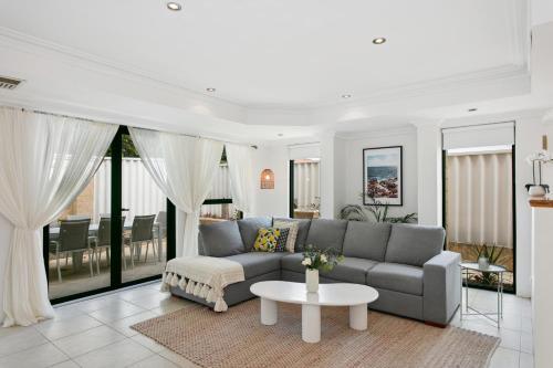 a living room with a couch and a table at Entire Home Steps to Sorrento Beach in Perth