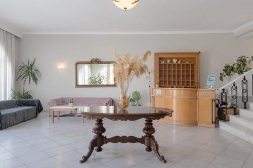 a living room with a table with a vase on it at Hotel Mironi and Victoria in Limenas