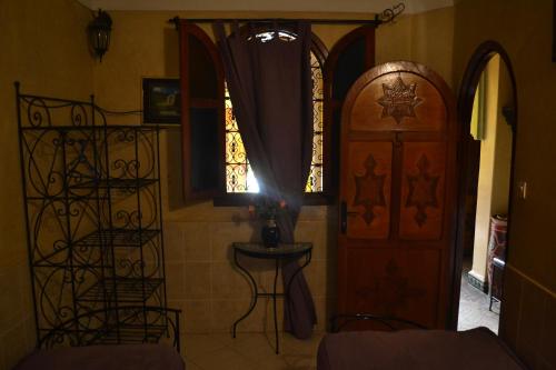 a room with a wooden door and a window at Riad Hôtel Belleville Marrakech in Marrakech