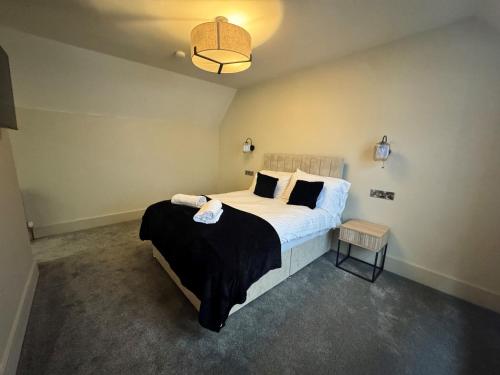 a bedroom with a large bed with a black blanket at Sandbed in Hawick