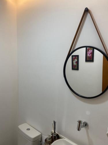 a bathroom with a mirror above a toilet at Apartamento exclusivo COP 30 in Belém