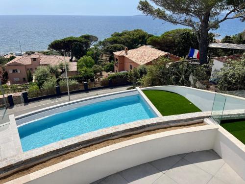 une piscine devant une maison dans l'établissement Appartement vue mer, piscine, 150m de la plage, Les Issambres, aux Issambres