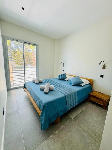 une chambre avec un lit avec des draps bleus et une fenêtre dans l'établissement Appartement vue mer, piscine, 150m de la plage, Les Issambres, aux Issambres
