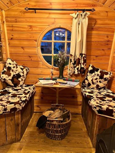 a room with two benches and a table in a cabin at Burtree Country House, Tipi's, Treehouse & Lodge & house rooms with hot tubs in a private garden in Thirsk