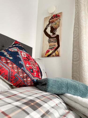 a bed with a pillow and a picture on the wall at Stanton - Stylish 2 Bedroom in Dagenham