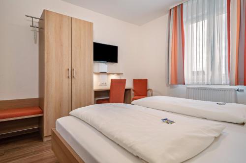 a hotel room with two beds and a desk at Gasthof Adler in Ebenweiler