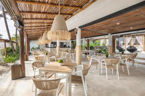 a restaurant with tables and chairs and a ceiling at Areia Playa del Carmen - Beach Front Hotel in Playa del Carmen