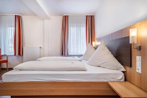 a hotel room with two beds in a room at Gasthof Adler in Ebenweiler