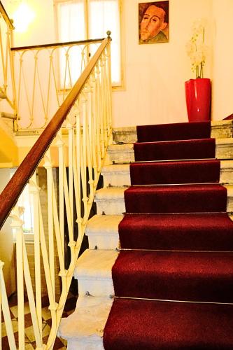 a stairway with red carpet and a red vase at H O T E L S A N G A L L O l in Venice