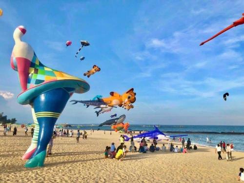 a group of people on a beach flying kites at KB Villas 58 in Bình Sum