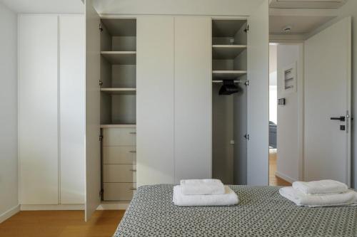 a bedroom with white cabinets and two towels on a bed at Luxurious Athens Residence in Athens