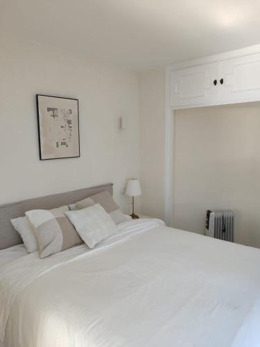a white bedroom with a large white bed at Pinos de Calahonda duplex in Sitio de Calahonda