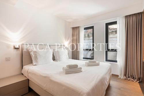 une chambre avec un lit blanc avec deux serviettes dessus dans l'établissement Paca Properties -401- 5 Chambres Luxe, à Cannes