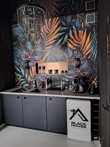 a kitchen with a sink and a tropical wallpaper at Black House A in Radom