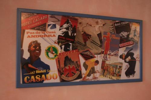 a picture hanging on a wall with posters on it at Hotel Casado in Pas de la Casa